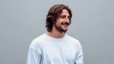 Portrait of Milo Arthur Johnson standing outdoors, looking away from the camera with a neutral expression.”